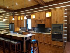 A kitchen with wood cabinets and a bar stools.