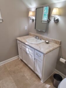 A white bathroom with a sink and mirror.