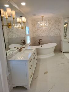 A white and gold bathroom with a tub and sink.