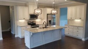 A kitchen with white cabinets and granite counter tops.