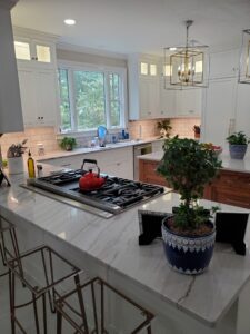 A kitchen with marble counter tops and stools.