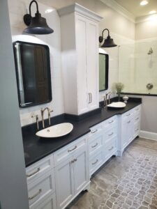 A black and white bathroom with two sinks and a mirror.