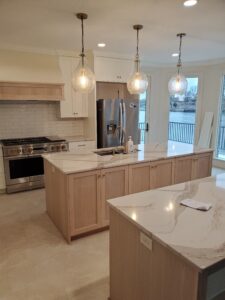 A kitchen with marble counter tops and stainless steel appliances.