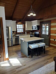 A kitchen in a log cabin with wood floors.