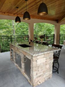 An outdoor kitchen with a stone counter top.