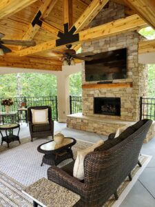 An outdoor living area with a fireplace and wicker furniture.