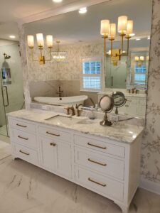 A beautiful mirror with yellow lamps and cabinets