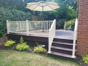 A wooden deck with an umbrella and steps.